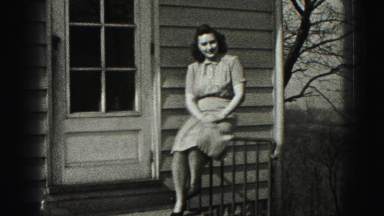 Woman in a 1940s-style dress sits on a porch railing outside a house in New Cumberland, Pennsylvania.