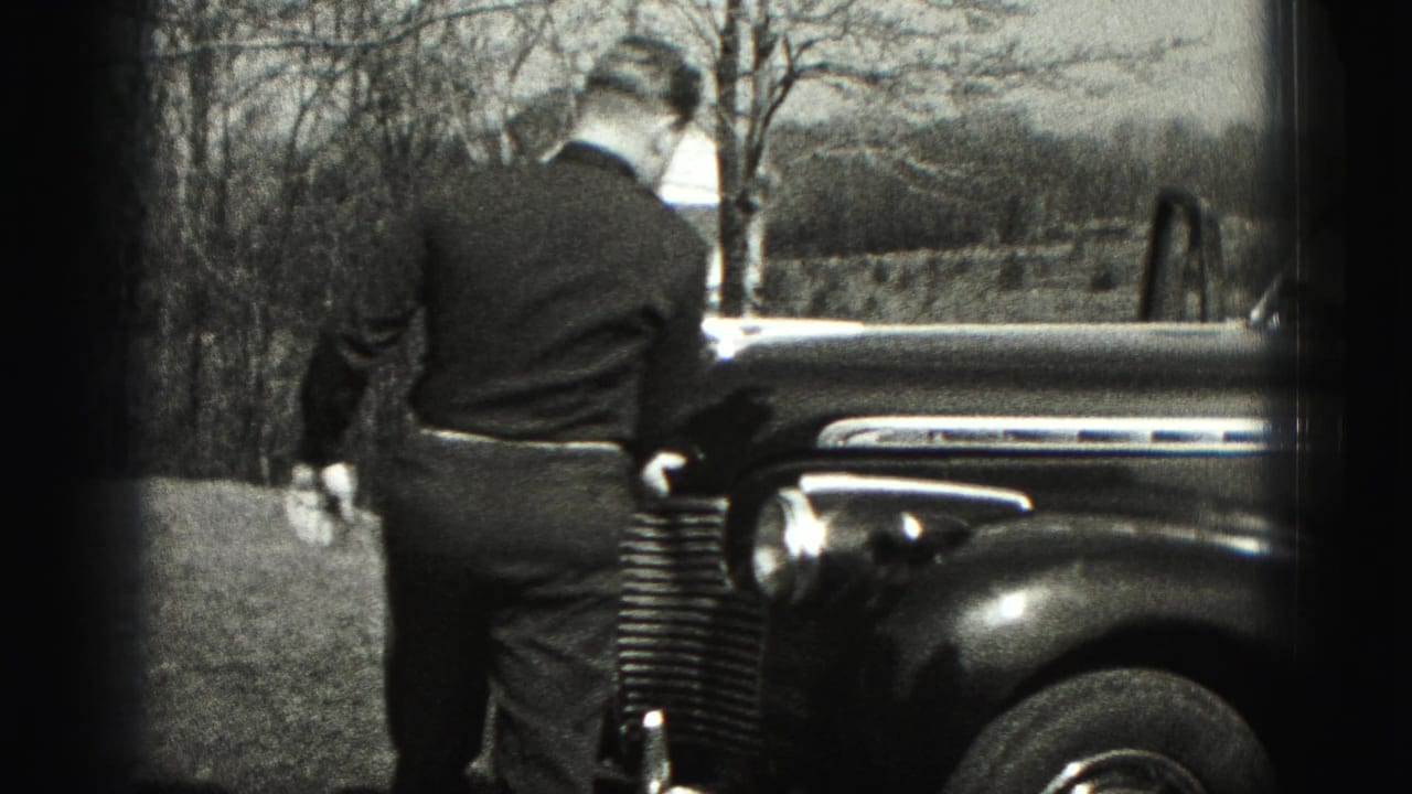 In New Cumberland, Pennsylvania in 1946, a man approaches a rounded vintage sedan parked near bare trees.