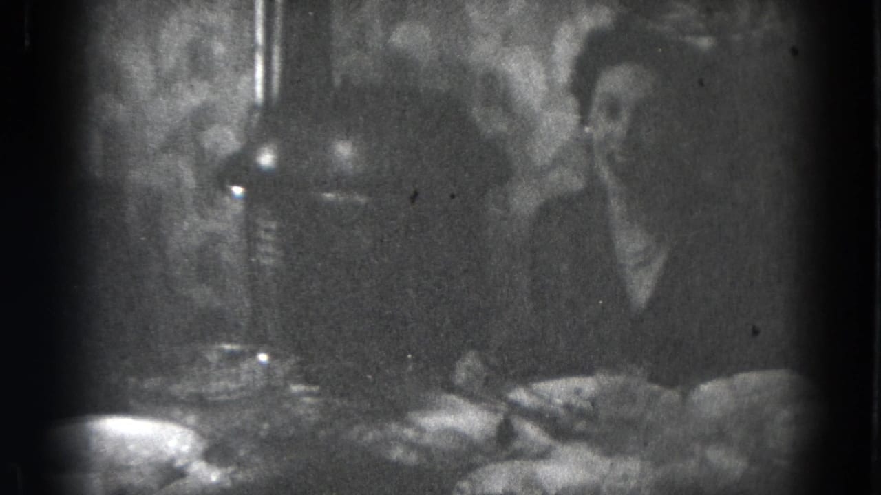 Dim 1947 Lincoln, Nebraska interior frame with adults at a table set with food, bowls, and glasses.