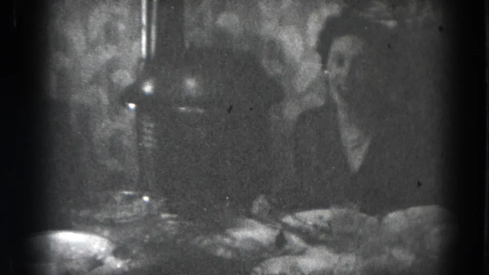 Dim 1947 Lincoln, Nebraska interior frame with adults at a table set with food, bowls, and glasses.