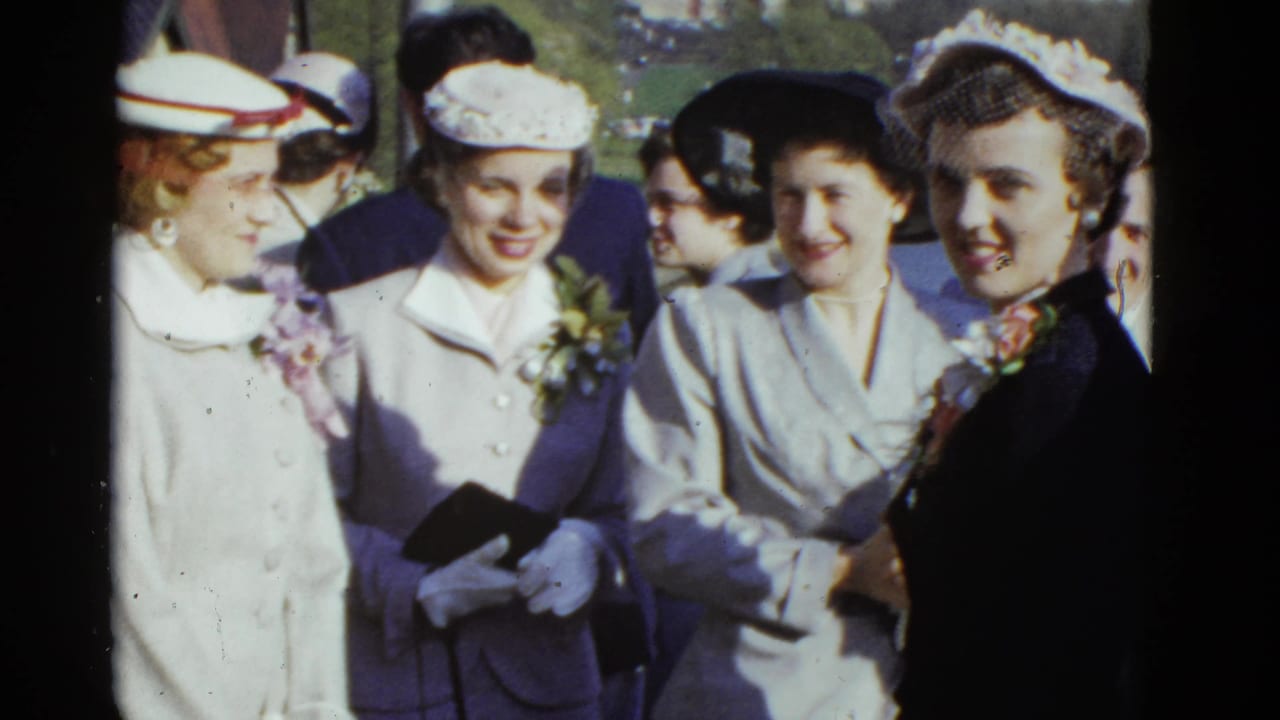 Women in 1950s hats, gloves, coats, and corsages stand close together outdoors in Boston, according to clip metadata.