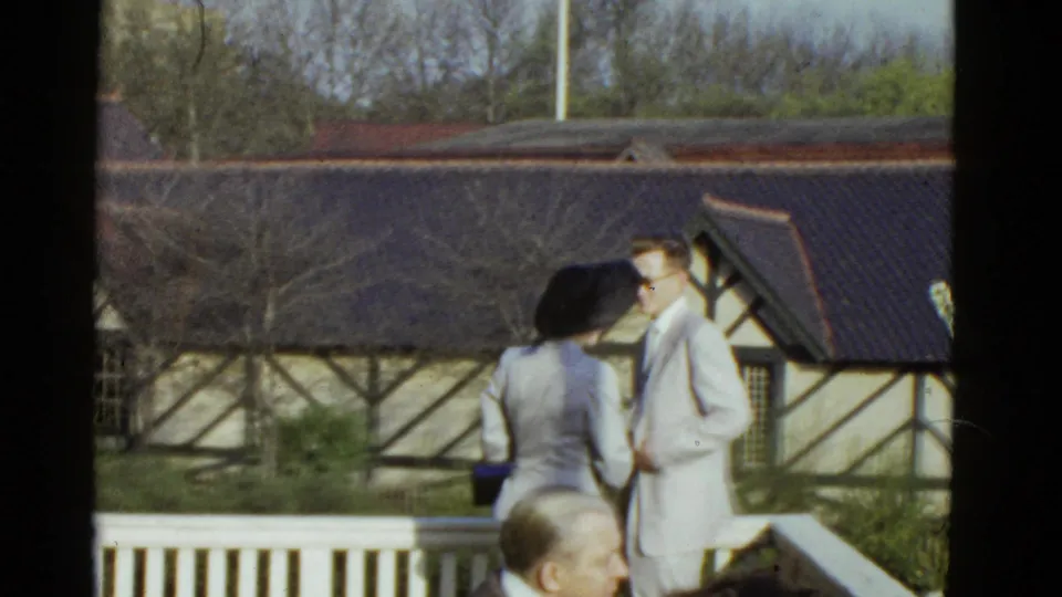 At the end of the 1951 Boston clip, the woman in a black hat appears to face the man in a light suit on the porch.