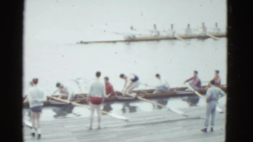 1951 Boston rowing footage showing multiple shells beside a dock, with people arranging oars and watching from the boards.