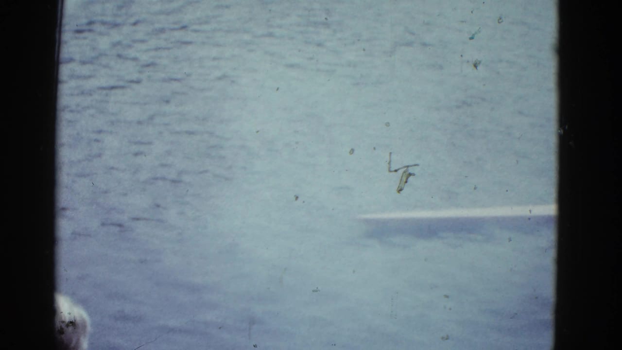 Water surface with a partial boat edge and film-frame borders.