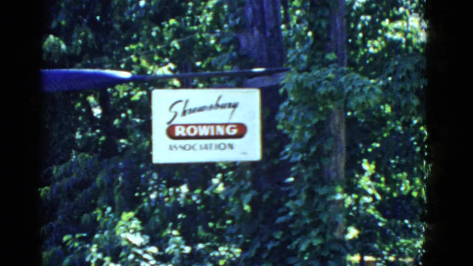 Soft 8mm frame from 1951 showing the Shrewsbury Rowing Association sign amid green trees near Boston, Massachusetts.