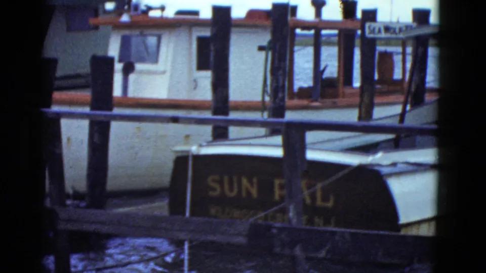 Boston dock scene from 1951 metadata showing the SUN PAL boat, wooden pilings, water, and a SEA WOLF sign in the background.