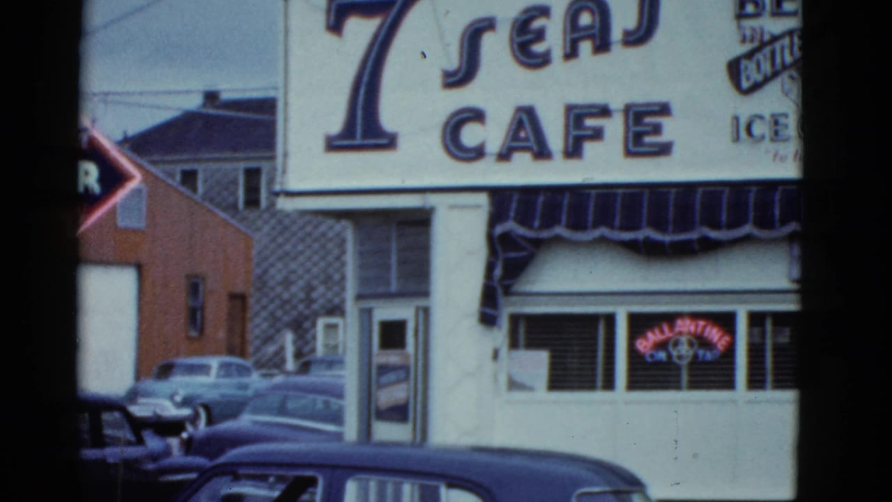 1951 Boston view of the Seven Seas Cafe exterior with large signage, striped awning, Ballantine neon, and mid-century cars.
