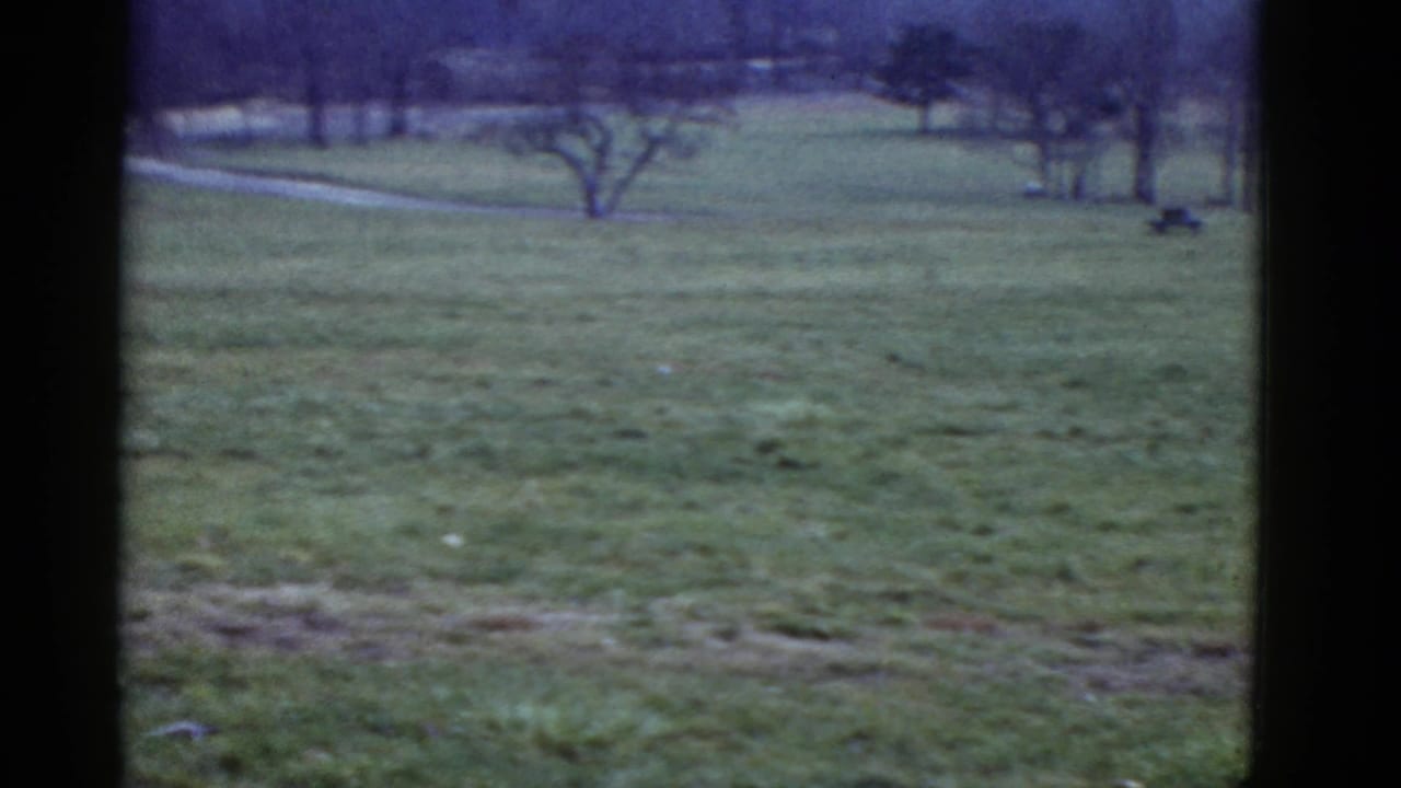 1951 Boston-area home-movie frame showing the open grassy running course before athletes pass the camera.
