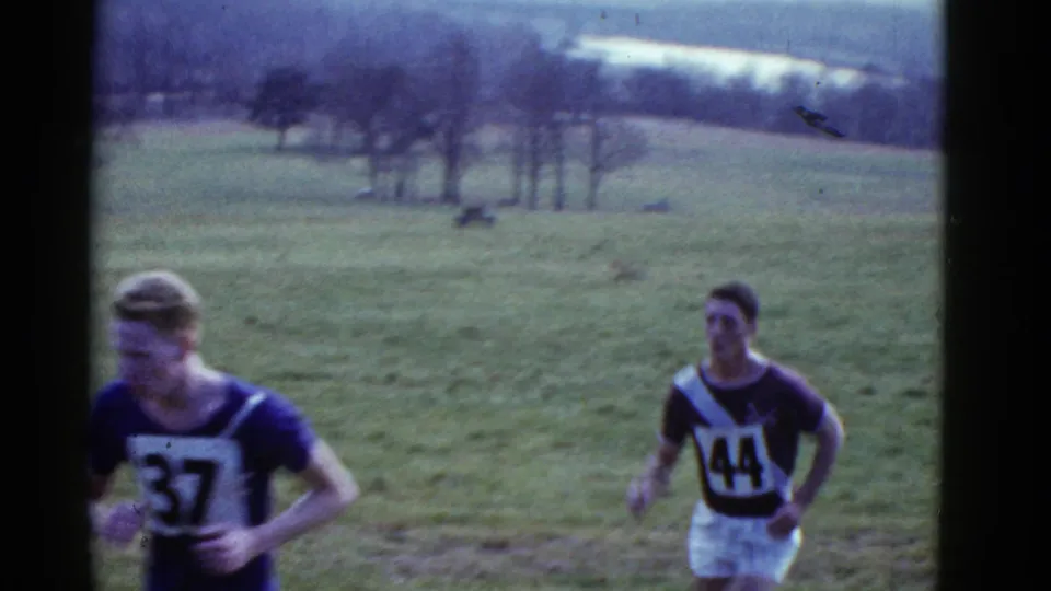 Two male cross-country runners, including bibs 37 and 44, pass through the 1951 Boston-area field course.