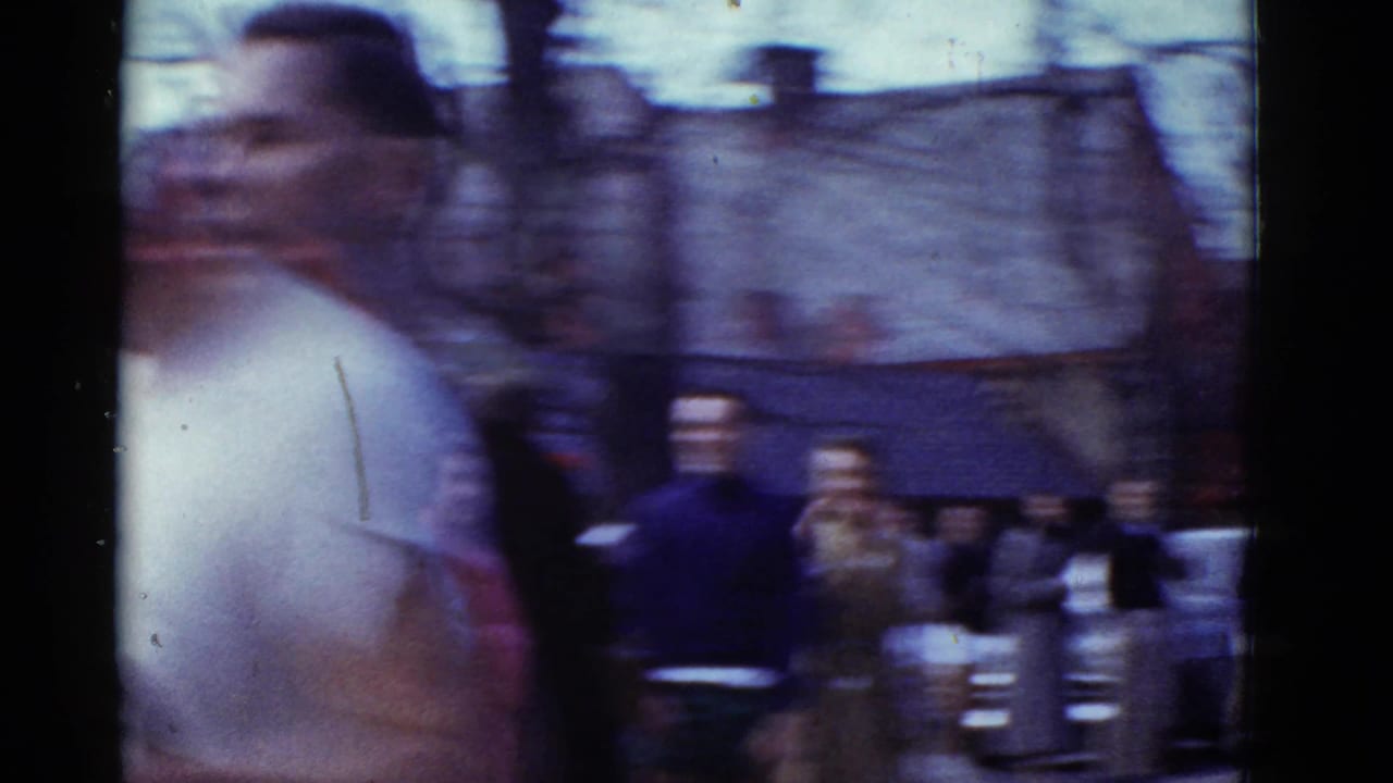 Blurred runner passing spectators on a city street.