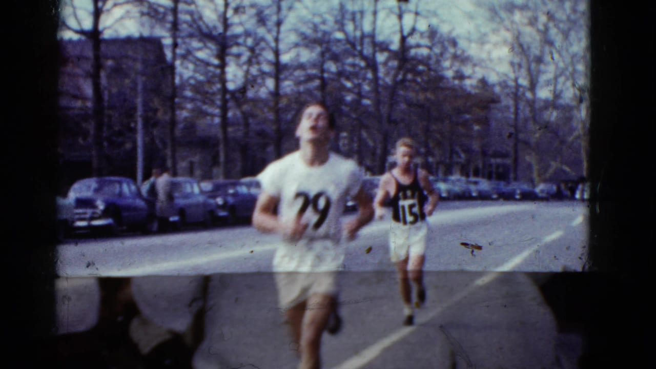 Runner number 79 passes close to the camera in a Boston road race, with another numbered runner following.