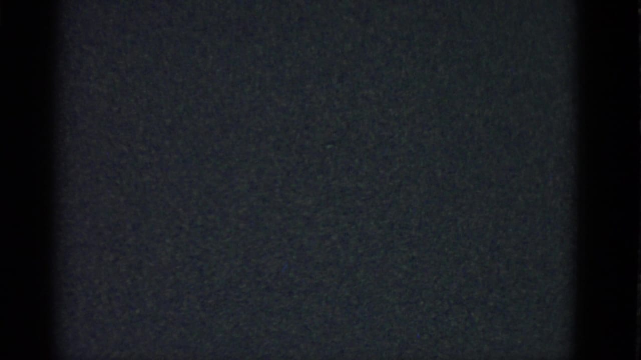 Very dark frame with vertical interior shadows and faint grain.