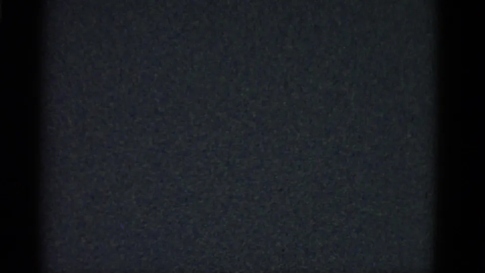 Low-light 8mm frame from the Boston 1951 footage showing dark vertical forms with no clear subject detail.