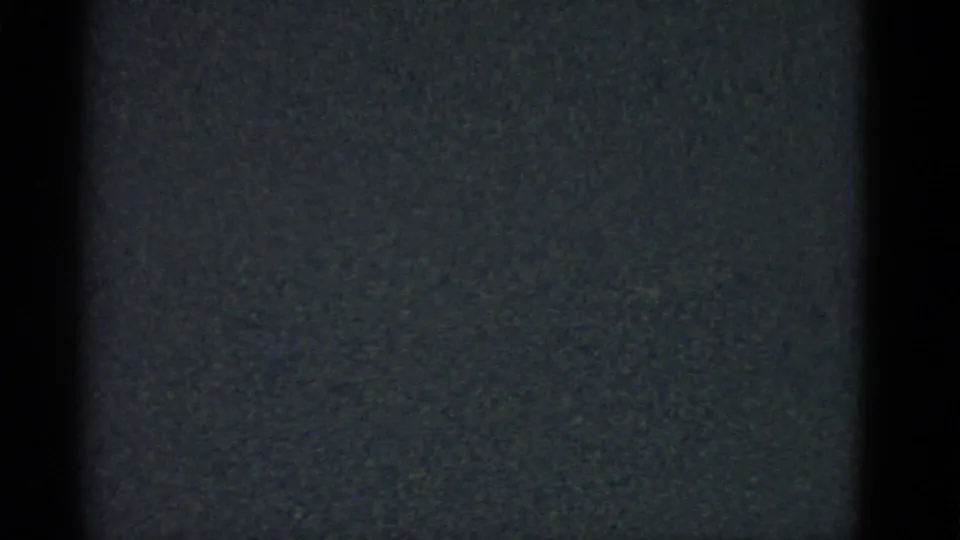 Dark 1951 Boston-labeled 8mm home-movie frame showing only faint grain, edge shadow, and tiny specks.