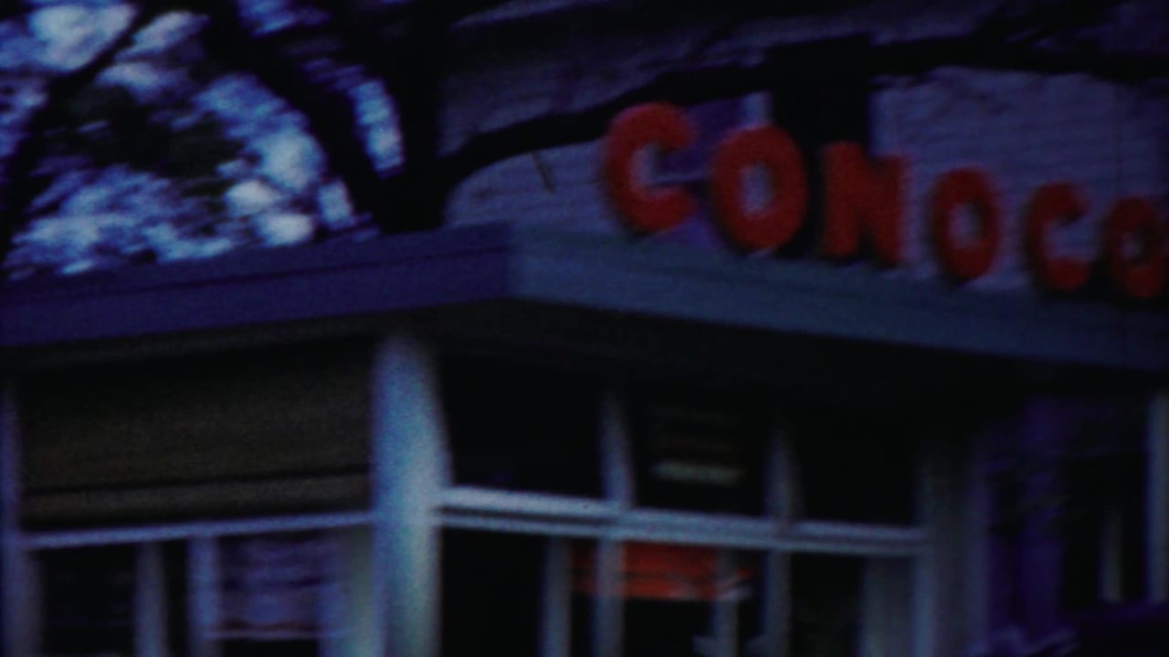 Roadside frame in Cheyenne County, Kansas showing part of a Conoco station sign, roofline, windows, and trees above.