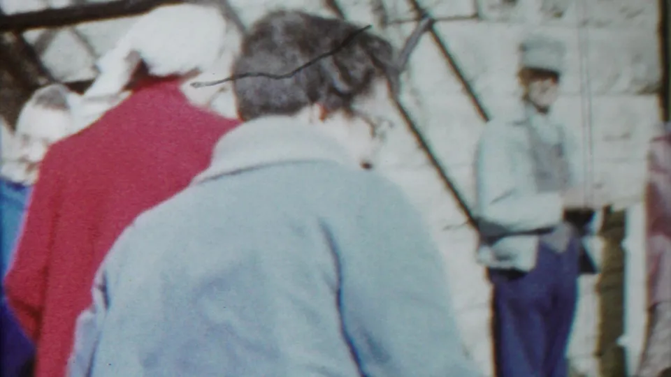 Brief, blurry home-movie view of people walking outdoors in Cheyenne County, Kansas, including a person in a light blue coat and others in winter clothing.