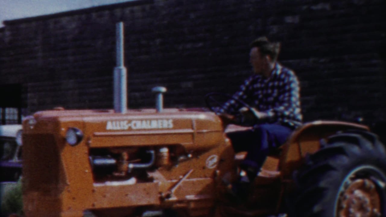 The tractor driver passes the camera in Cheyenne County, Kansas, with the Allis-Chalmers name visible on the orange hood.