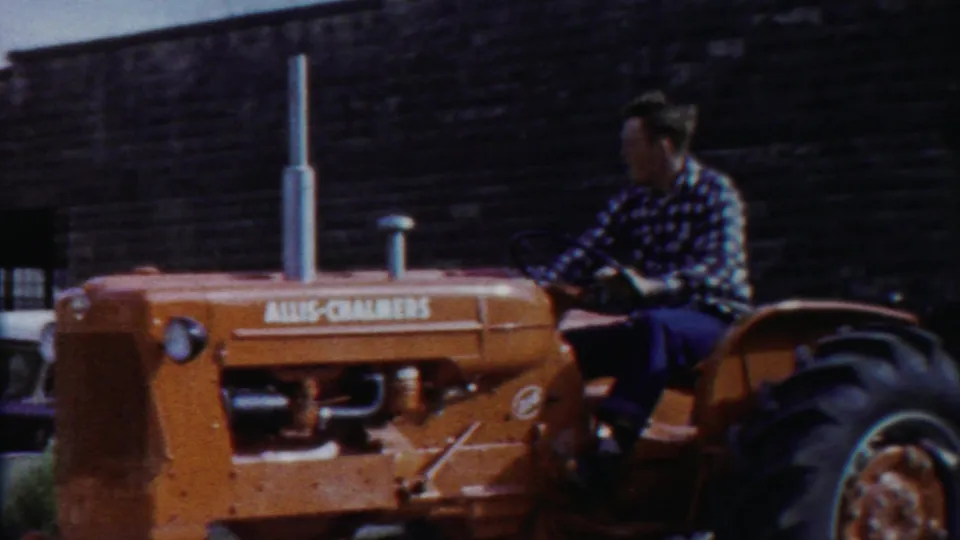 The tractor driver passes the camera in Cheyenne County, Kansas, with the Allis-Chalmers name visible on the orange hood.
