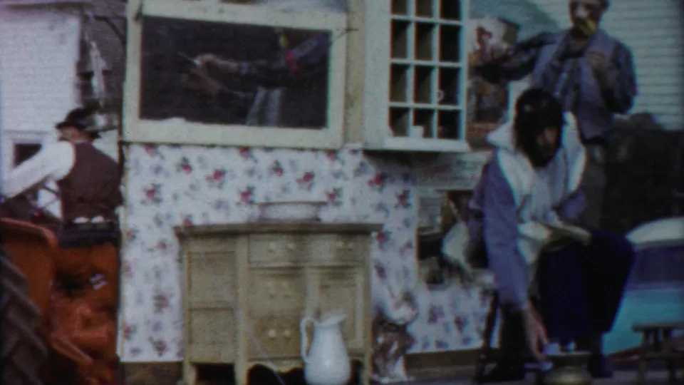 A barbershop-themed parade float in the 1958 Kansas footage shows seated and standing costumed participants beside shop-like props.