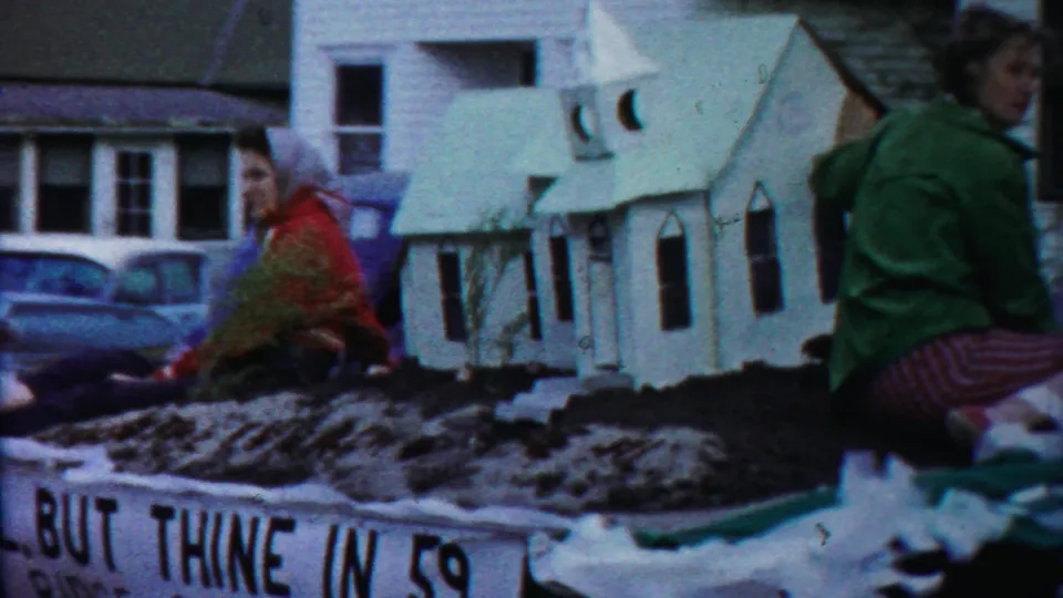 Cheyenne County parade float shows miniature churches on dark soil, women riders, 1950s cars, and partial text reading “BUT THINE IN 59.”