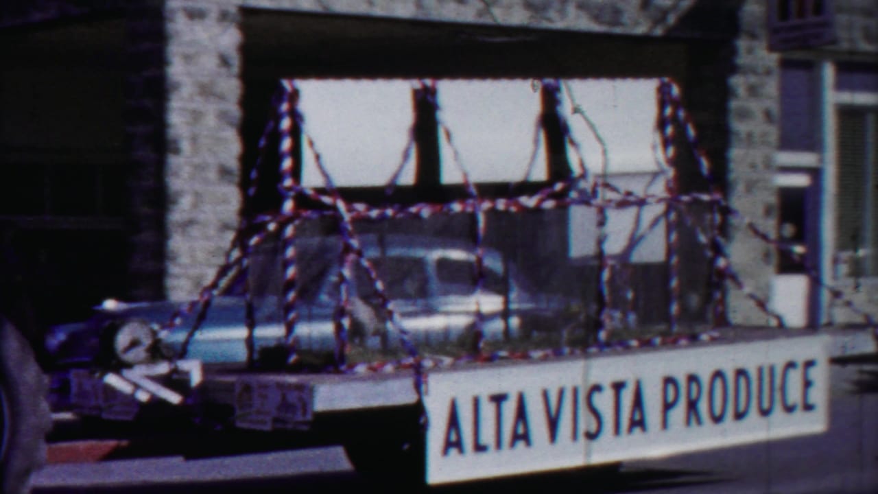 1958 Cheyenne County, Kansas parade float with caged pigs, patriotic streamers, and Alta Vista Produce signage on a town street.