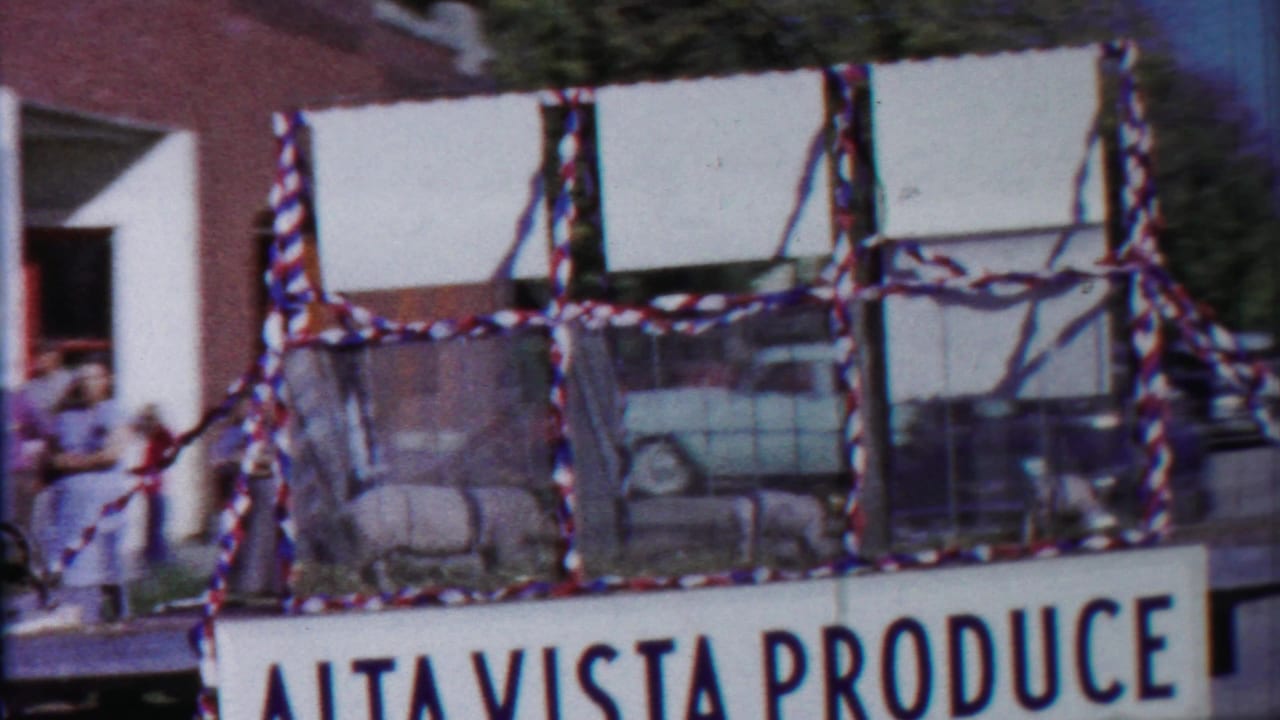 Decorated parade float with sheep and a large Alta Vista Produce sign.