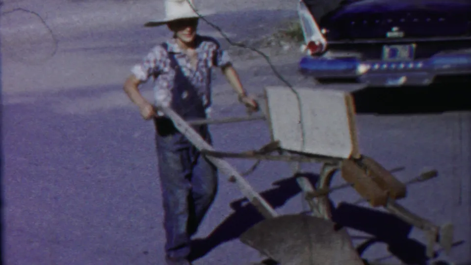 The final frame shows the man smiling or facing the camera while pulling the implement, with a mid-century car behind him.