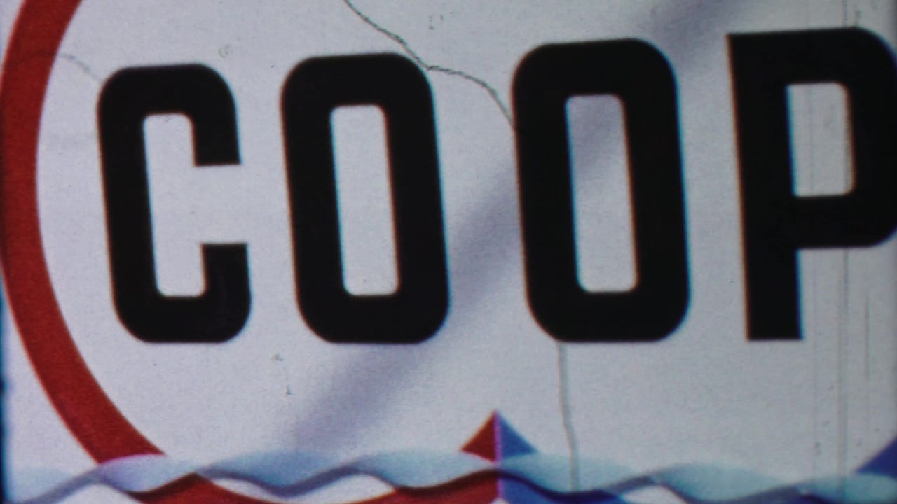 Close view of large COOP letters on a white sign with red and blue trim.