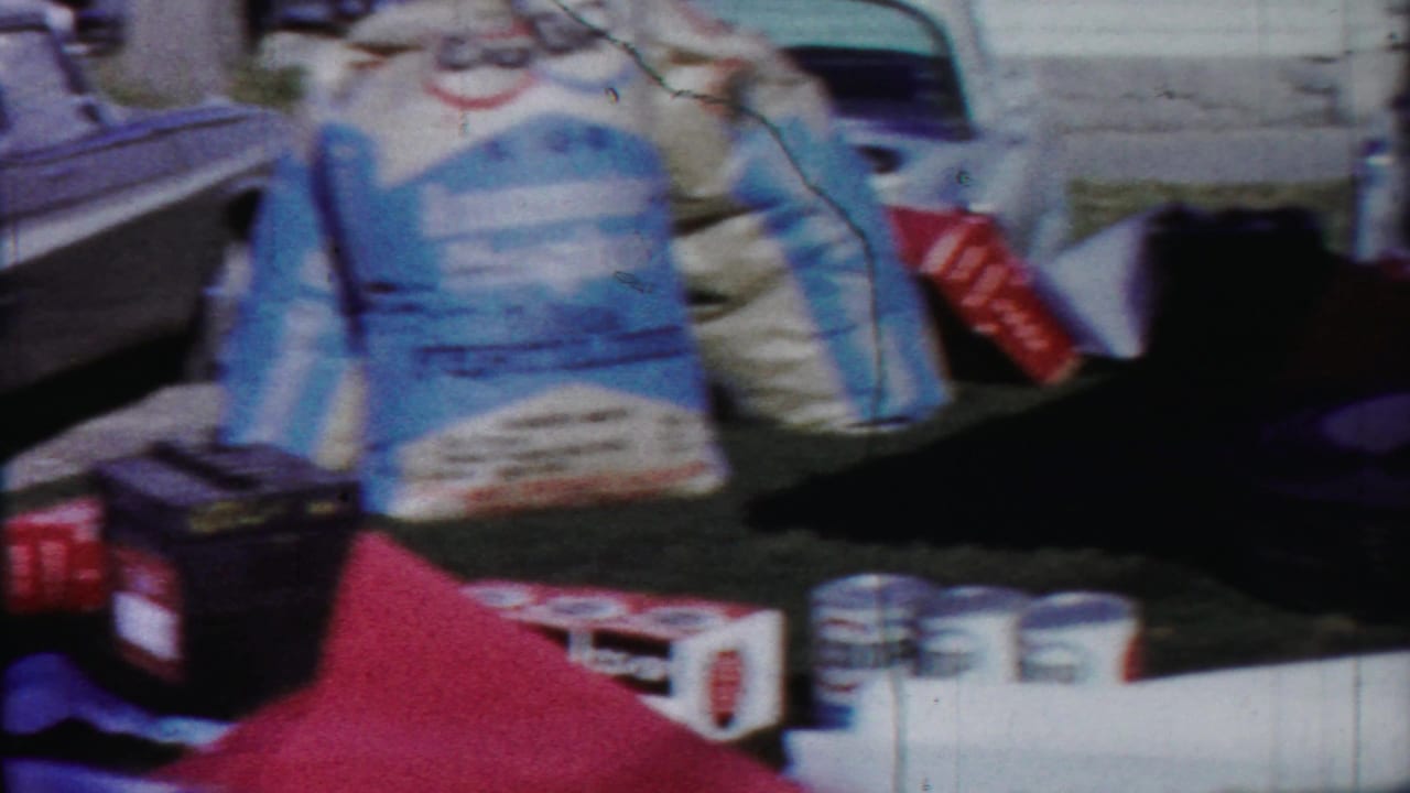 Blurred street-level view with bags or signs in the foreground and vintage traffic beyond.