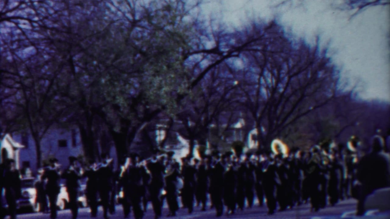 Cheyenne County parade footage shows the band crossing the frame under winter-bare trees and soft 8mm color.