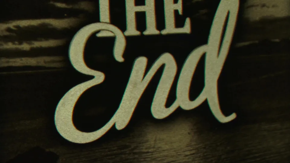 Closing home-movie title card with large THE END lettering over a dark scenic background.