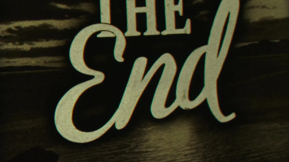 Final frame holds on the THE END card, with pale lettering and visible 8mm grain.