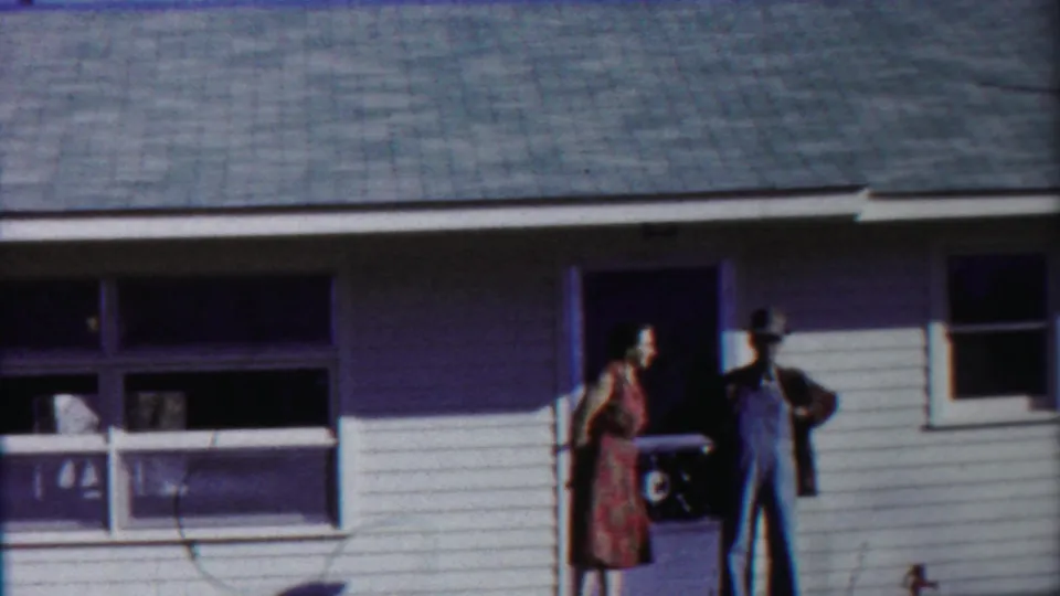 At the end of the 1958 Cheyenne County, Kansas clip, the woman moves toward the man in overalls beside the house porch.