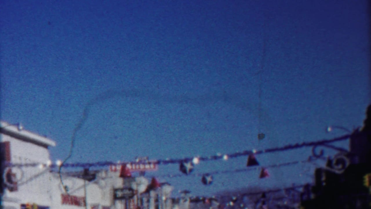 Low-angle home-movie view of Christmas street decorations and commercial signage in Cheyenne County, Kansas, in 1958.