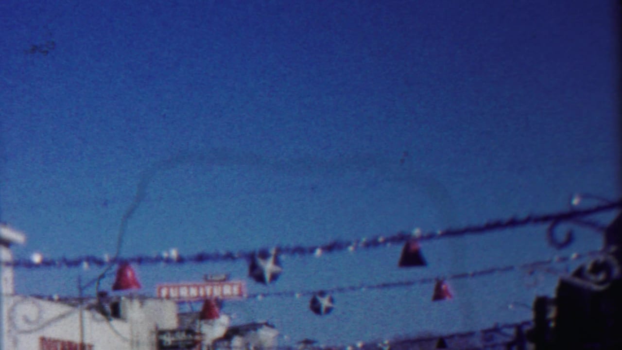 End frame of a 1958 Cheyenne County street scene with Christmas ornaments hanging above storefronts.
