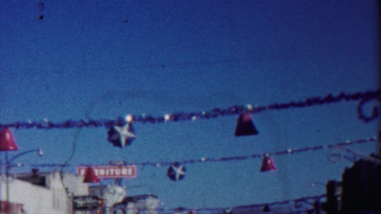 Town street decorations with red bells, white stars, and a partial furniture sign below.