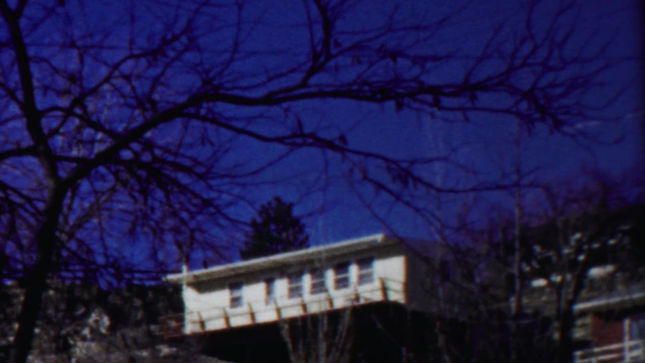 1958 Cheyenne County frame showing a white house at left, bare tree silhouettes, and winter light across the scene.