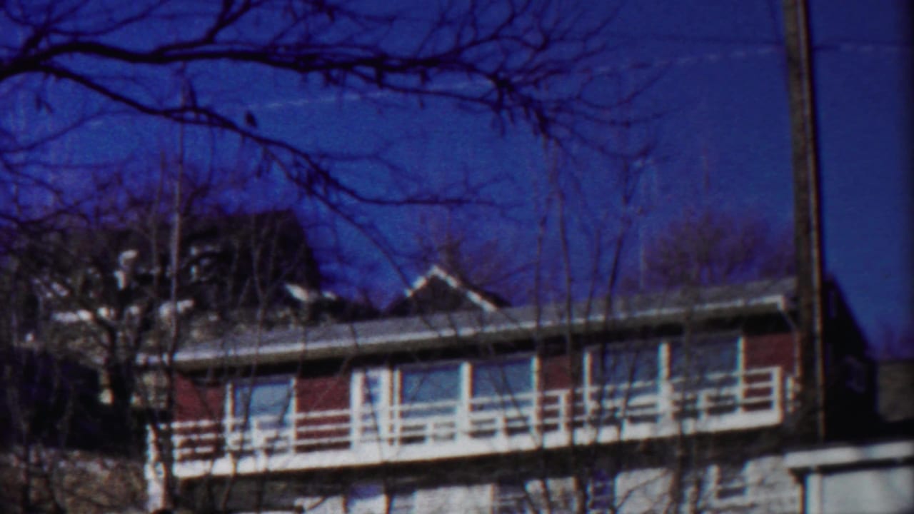1958 Cheyenne County, Kansas 8mm view of a red brick apartment exterior with white balcony rails and bare trees.