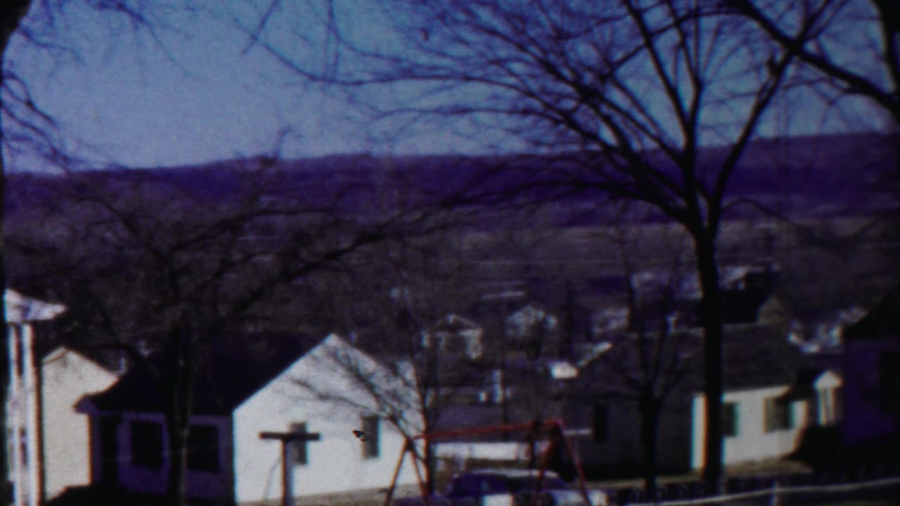 1958 Cheyenne County, Kansas view across modest homes and leafless trees toward rolling hills in the distance.
