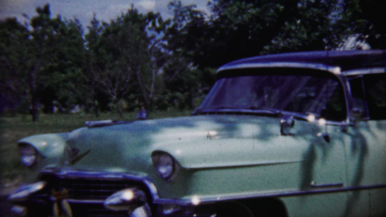 A light green mid-century car with chrome trim sits outdoors near trees in Saint Francis, Kansas, according to the clip metadata.