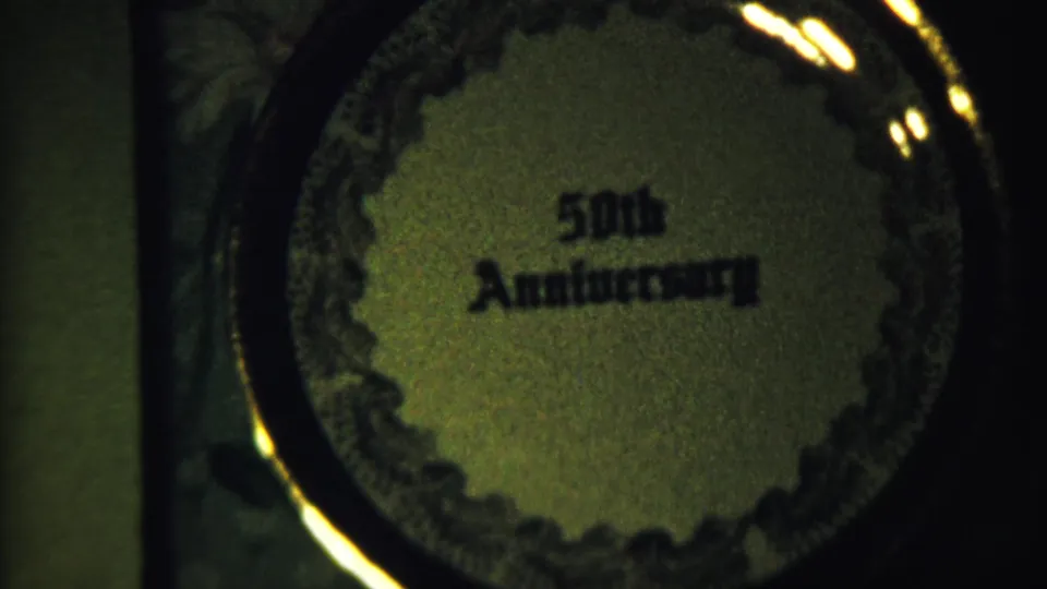 Saint Francis, Kansas home-movie frame showing a close-up of the circular 50th Anniversary plaque in soft focus.