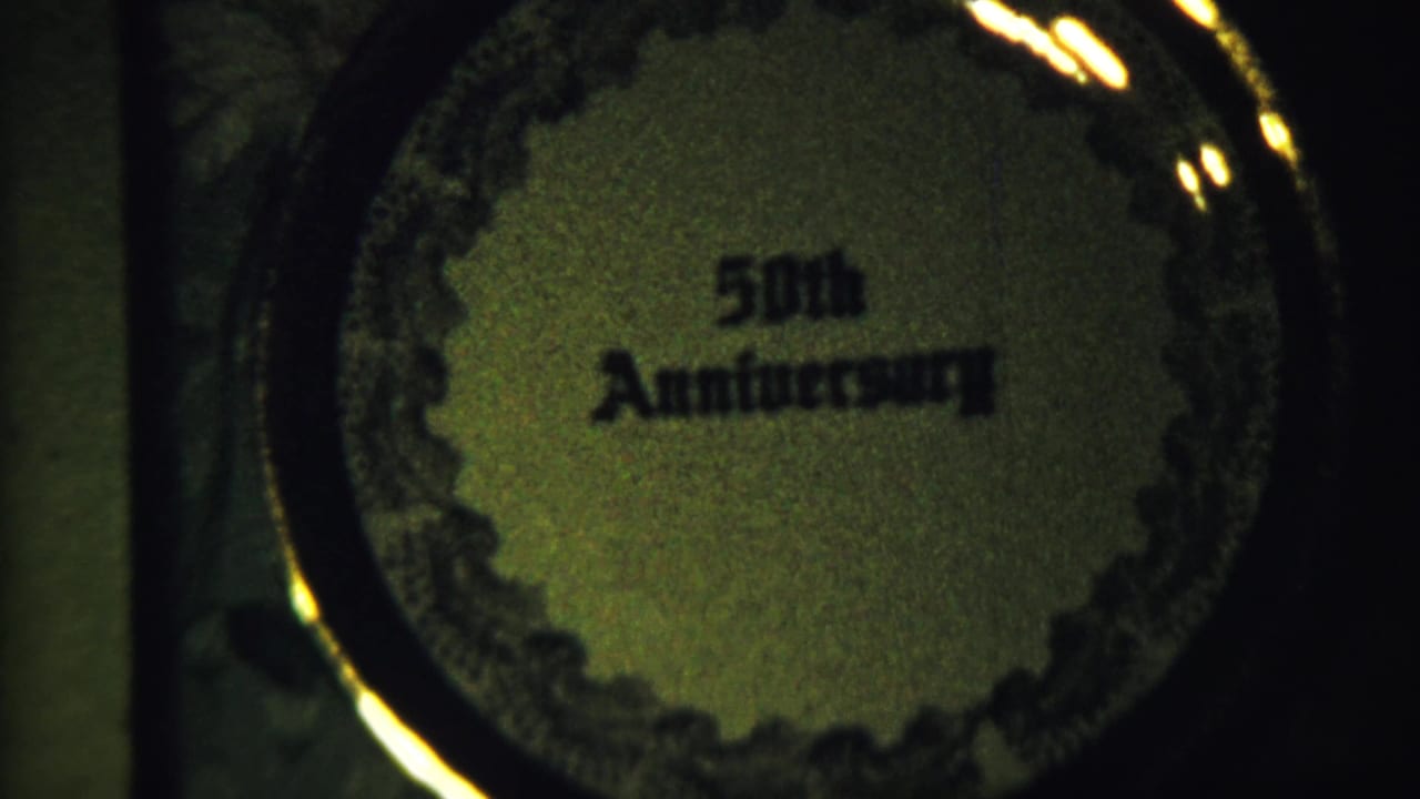 Close view of a circular 50th Anniversary design with ornate border and dark rim.