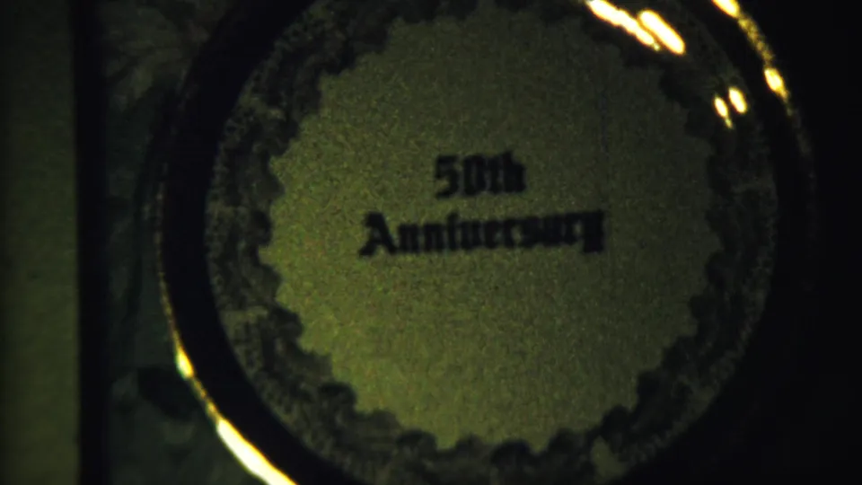 1958 Saint Francis, Kansas 8mm frame showing a circular 50th Anniversary keepsake or textile in soft greenish light.