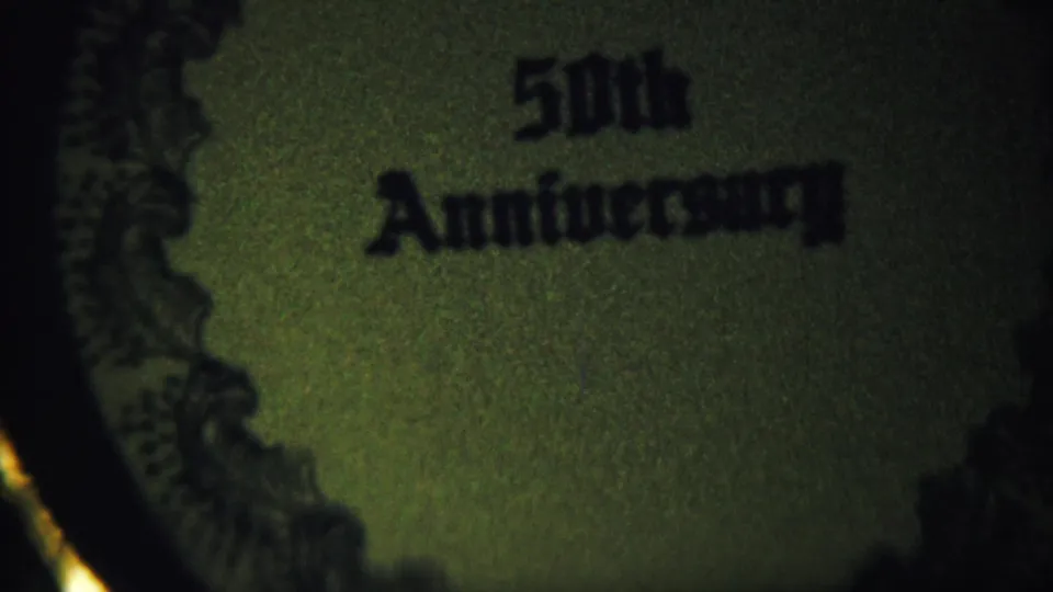 Tight 1958 8mm close-up of 50th Anniversary lettering on a circular commemorative object or needlework piece.
