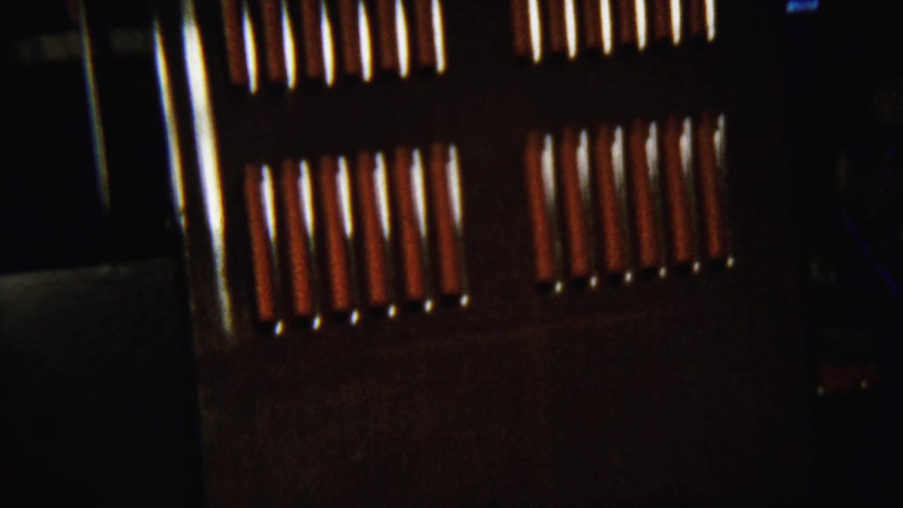 Dark wall or cabinet surface beside bright slats of light from nearby blinds.