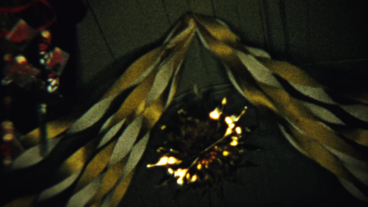 1958 Saint Francis, Kansas frame with mustard yellow and white streamers forming a loose V over a small bright light.
