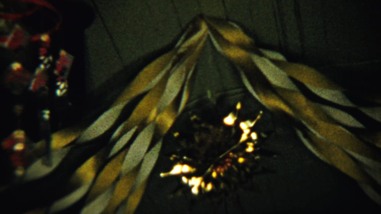 Gold and white twisted streamers hang from a dark ceiling with warm light reflections below.