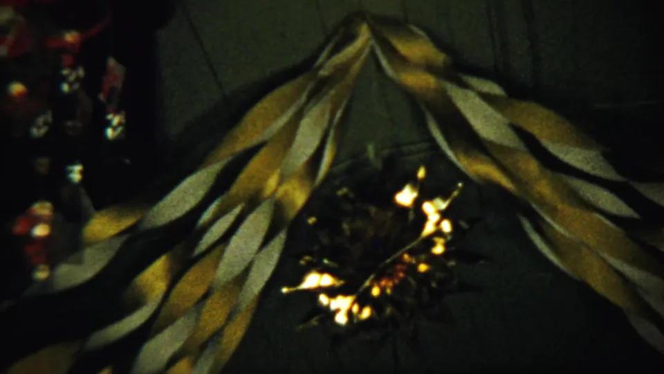 Final 8mm frame shows gold and white streamers in a dim 1958 Saint Francis, Kansas holiday interior.