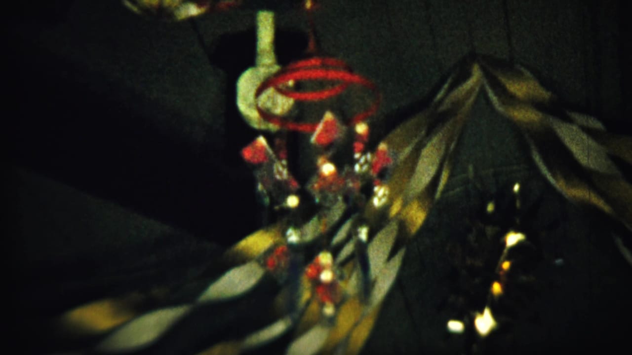 Hanging ornament and dark fabric surface seen in soft focus under low light.