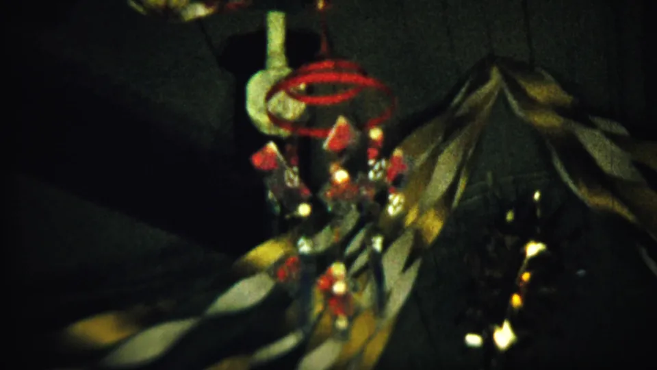 Low-light 8mm view of a red-accented hanging ornament above draped fabric in a Saint Francis, Kansas interior.